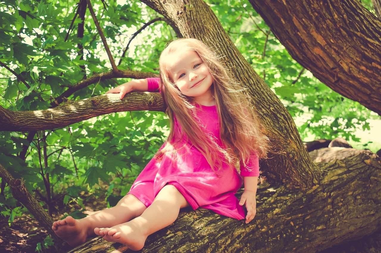 Niña subida en un arbol