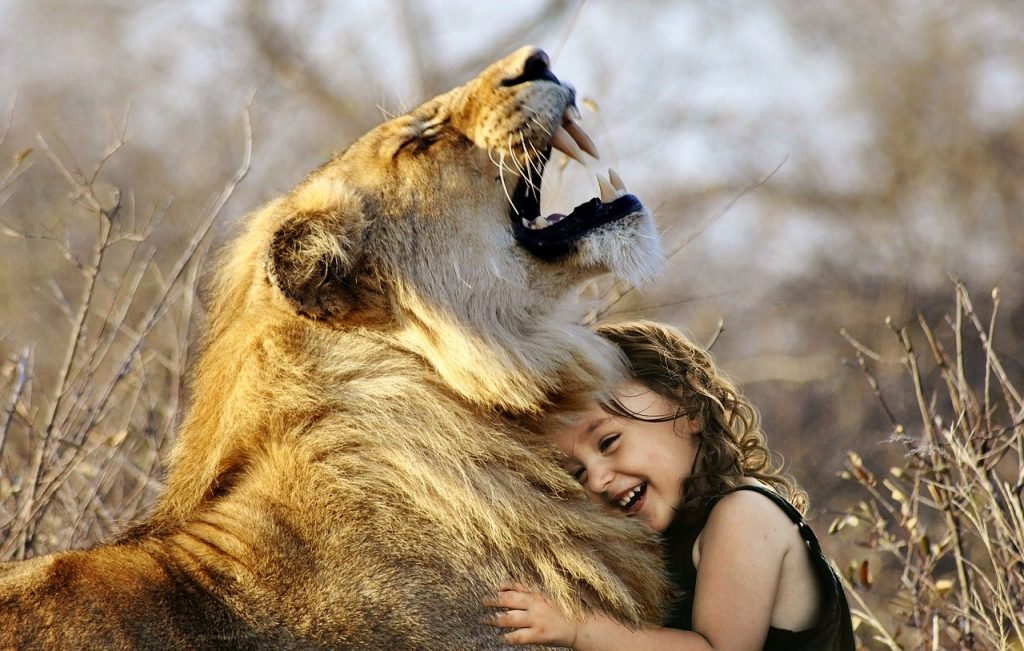 Niña abrazada a un león