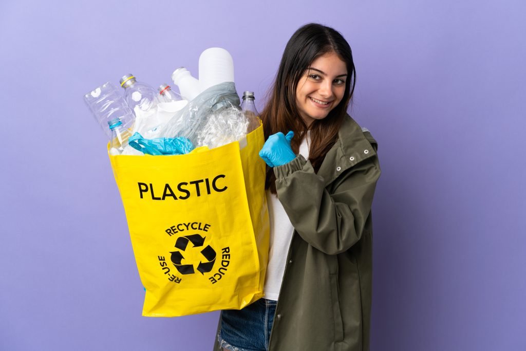 Mujer joven reciclando plástico